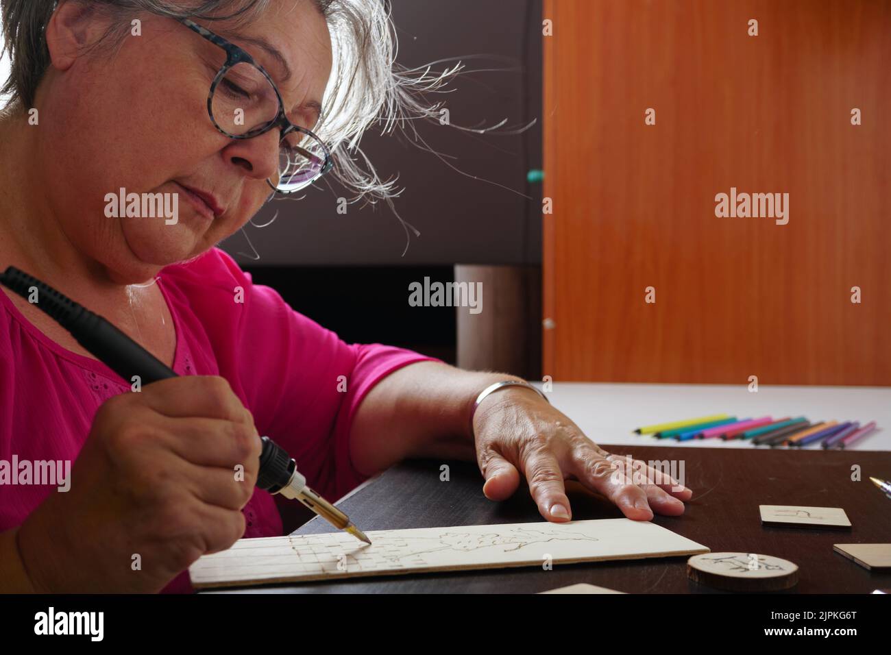 woman drawing with a pyrograph Stock Photo