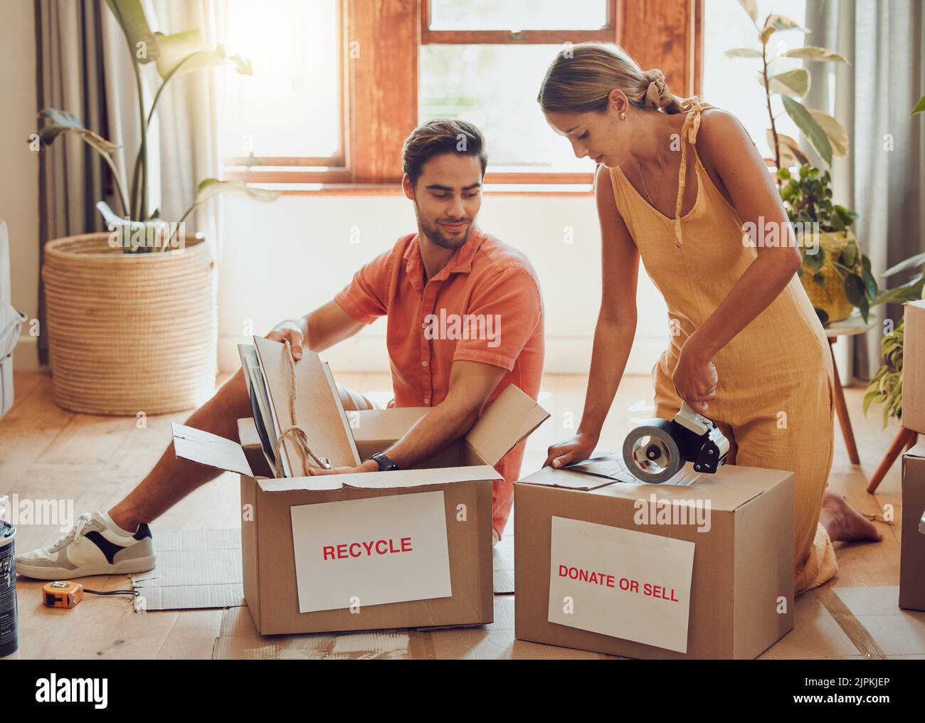 Donate, packing and boxes of a young couple working together to pack