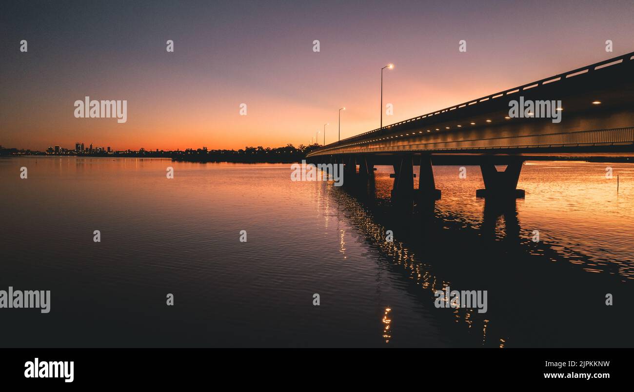 A silhouette of bridge reflecting on a water at sunset Stock Photo - Alamy