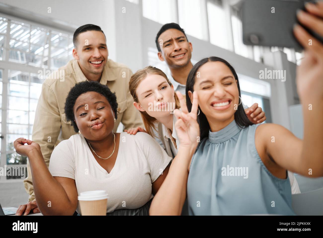 Fun, goofy or playful team selfie on phone and having fun, goofing around or making silly face expressions. Diverse or cheerful group of business Stock Photo