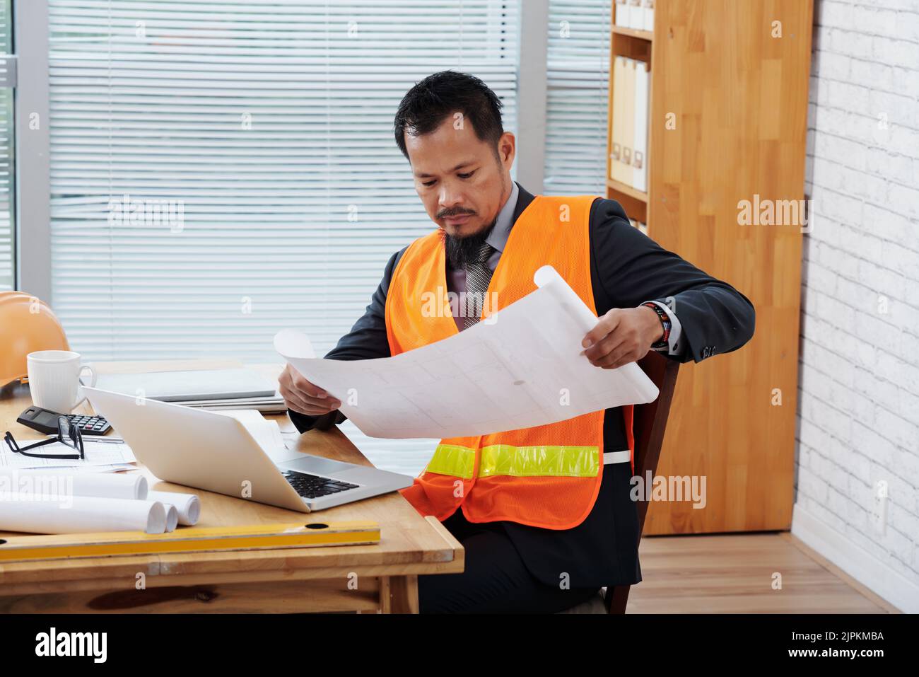 Portrait of Filipino architect examining construction plan Stock Photo