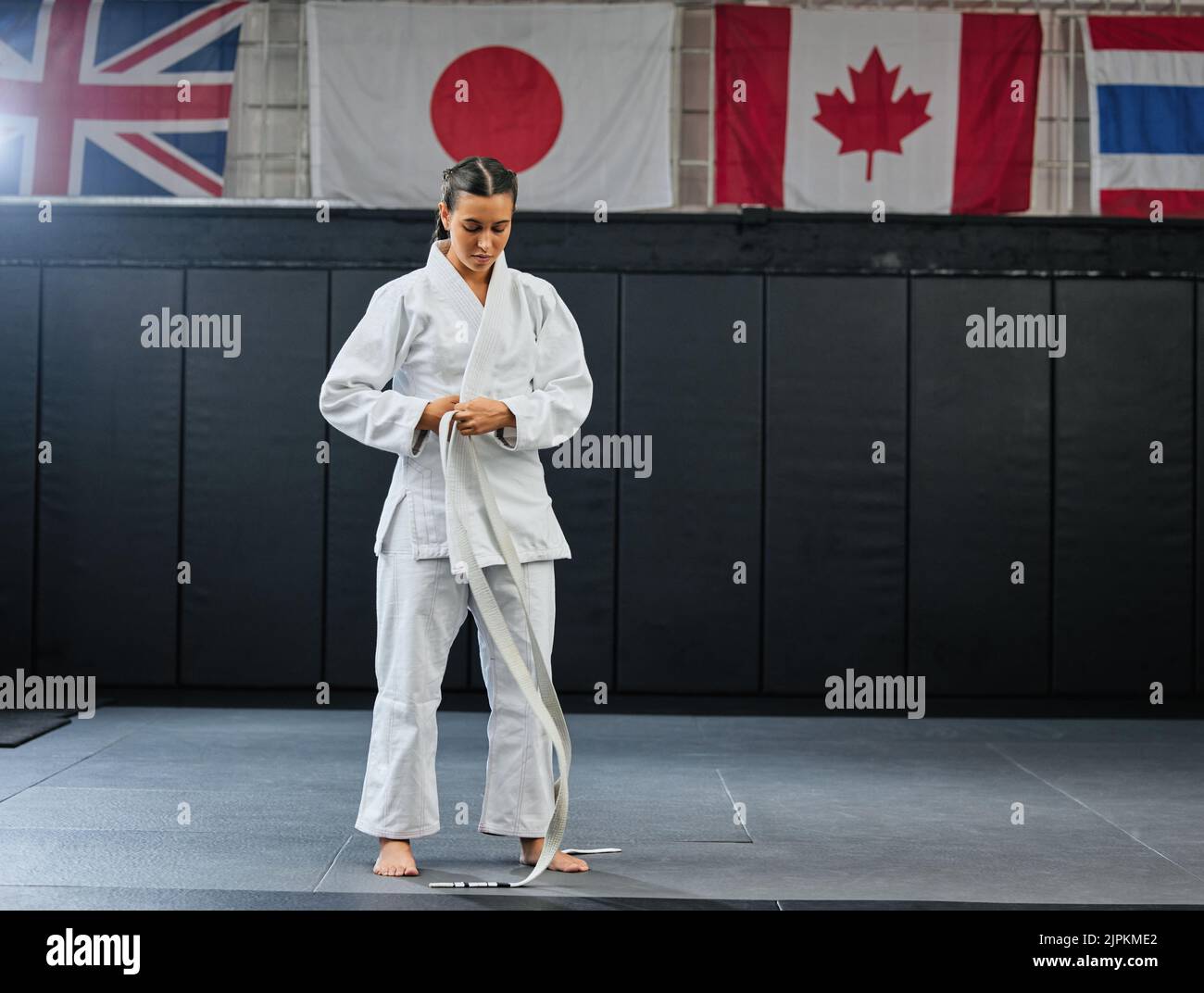 Professional karate student dressing and prepare for practice in a dojo or club. Female mix