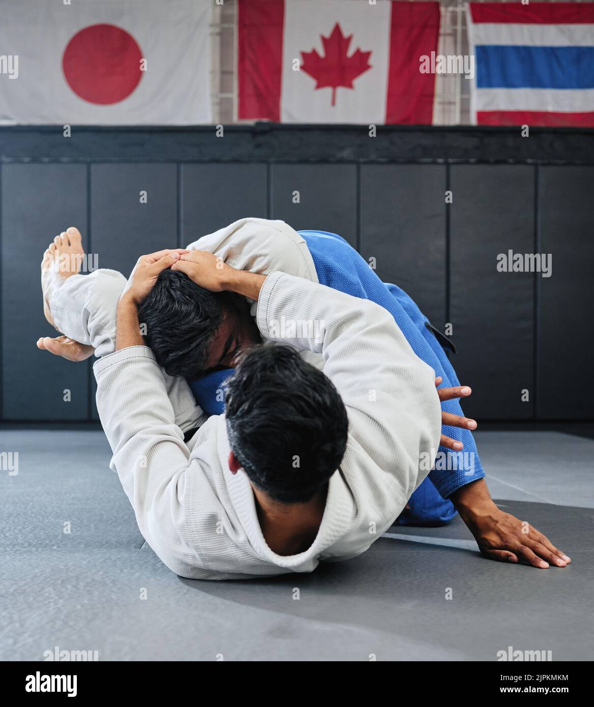 . Male martial arts, fighting at a dojo and holding his opponent. Karate, sports and taekwondo adults training at the gym for a fight. Athlete, aikido Stock Photo