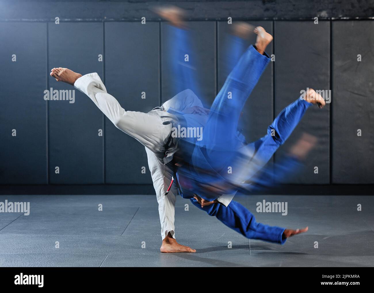 Fitness, strength and men in a karate fight in a gym for martial arts exercise. Action, motion and learning to take down the competition, training to Stock Photo