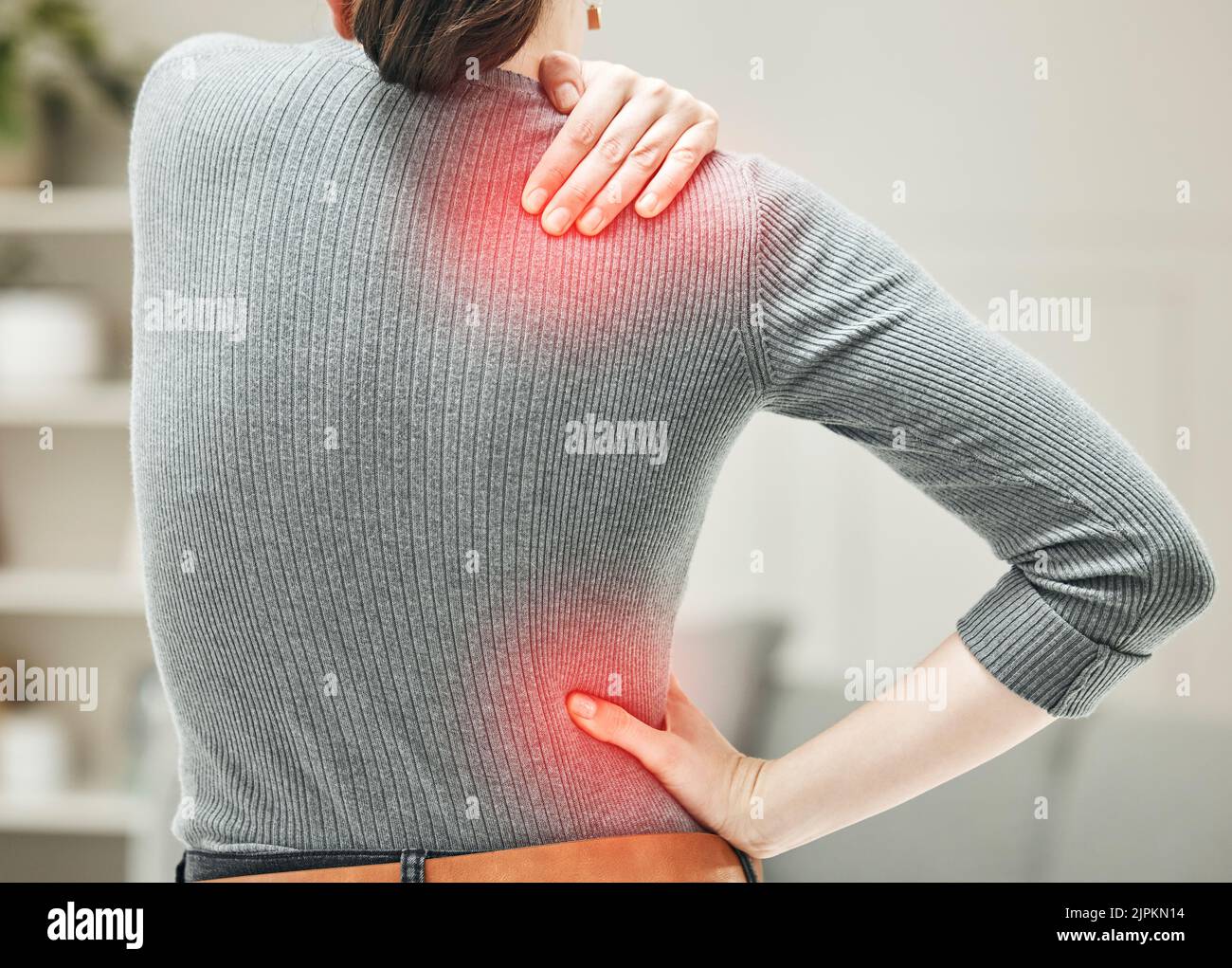 Shoulder, hip and back pain of a woman touching and holding a painful area on her body in red. Closeup of a female feeling strain, ache and discomfort Stock Photo