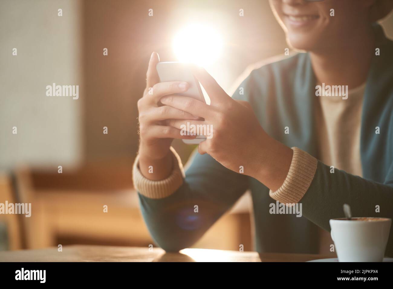 Smiling young man using application in his smartphone, backlit Stock Photo