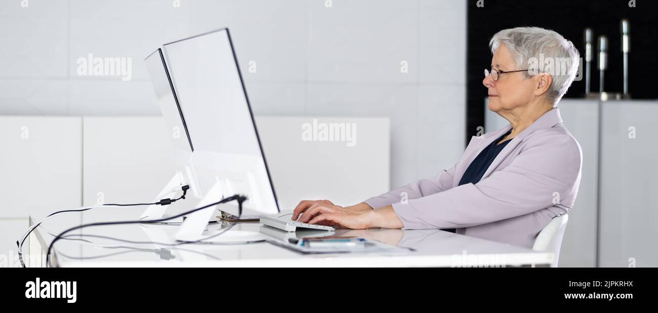 Bad Posture Sitting In Office Chair At Computer Desk Stock Photo