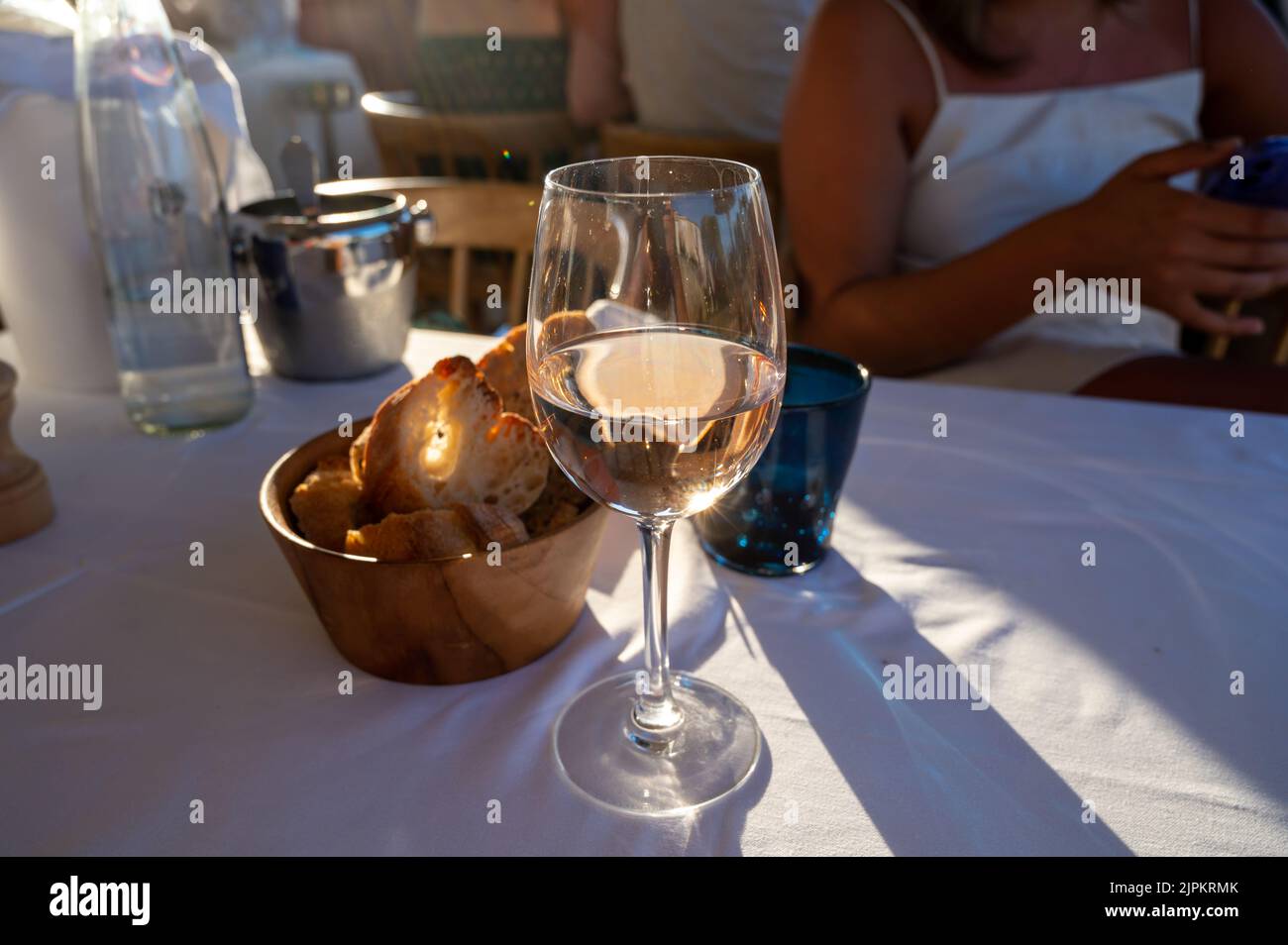 Dinner at sunset in French gourmet restaurant with cold dry rose wine in Port Grimaud, summer