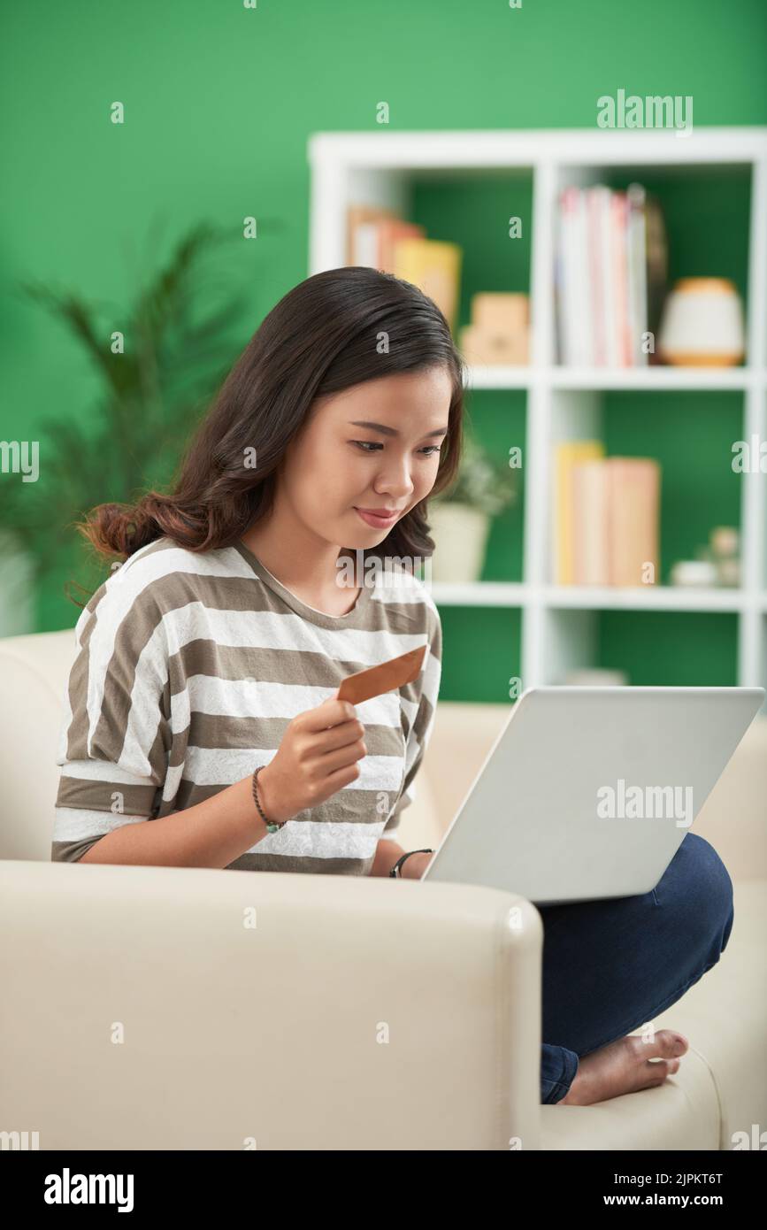Young Asian woman with laptop making orders from online store Stock Photo