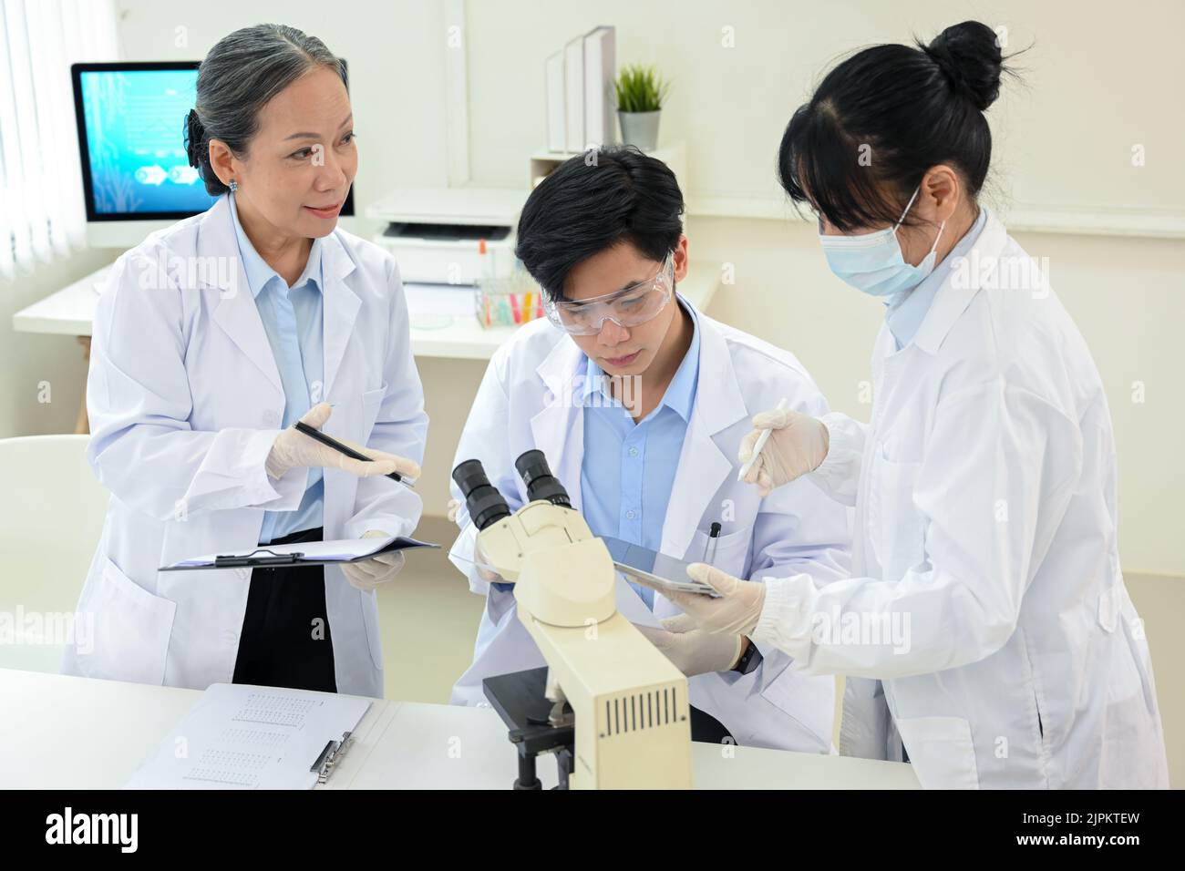 A professional and talented Asian scientist team is discussing and brainstorming on a new project in the lab. Stock Photo