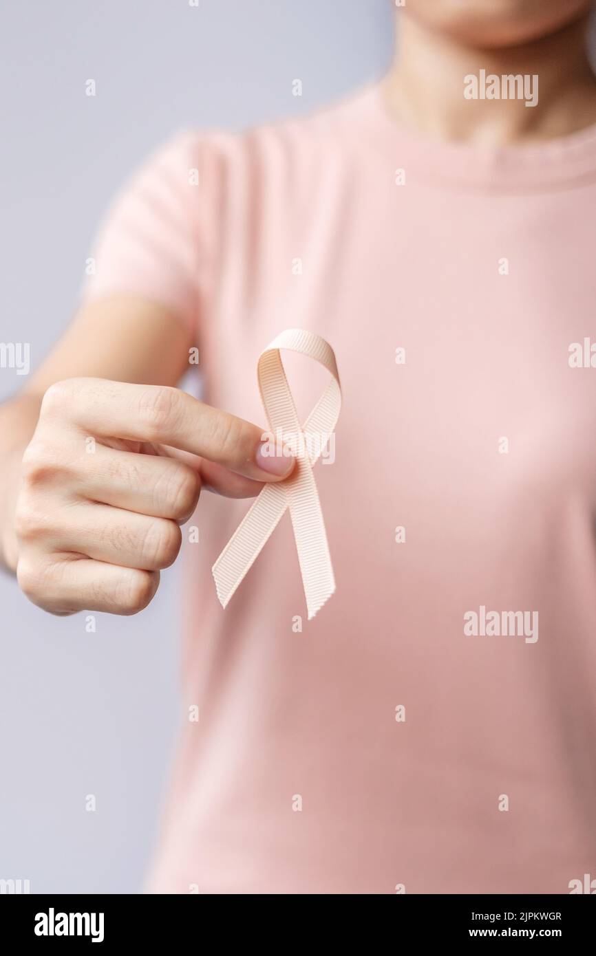 woman hand holding Peach Ribbon for September Uterine Cancer Awareness ...