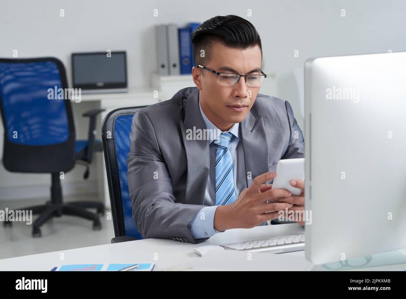 Asian entrepreneur using application on his smartphone Stock Photo