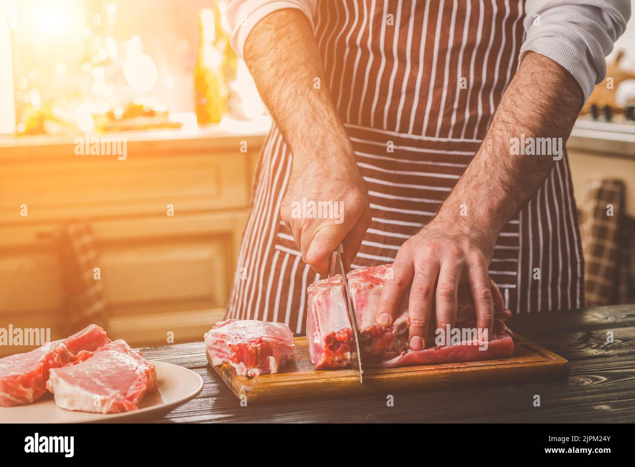 Chef cuts up meat on a cutting board with a sharp knife Stock Photo by  wirestock