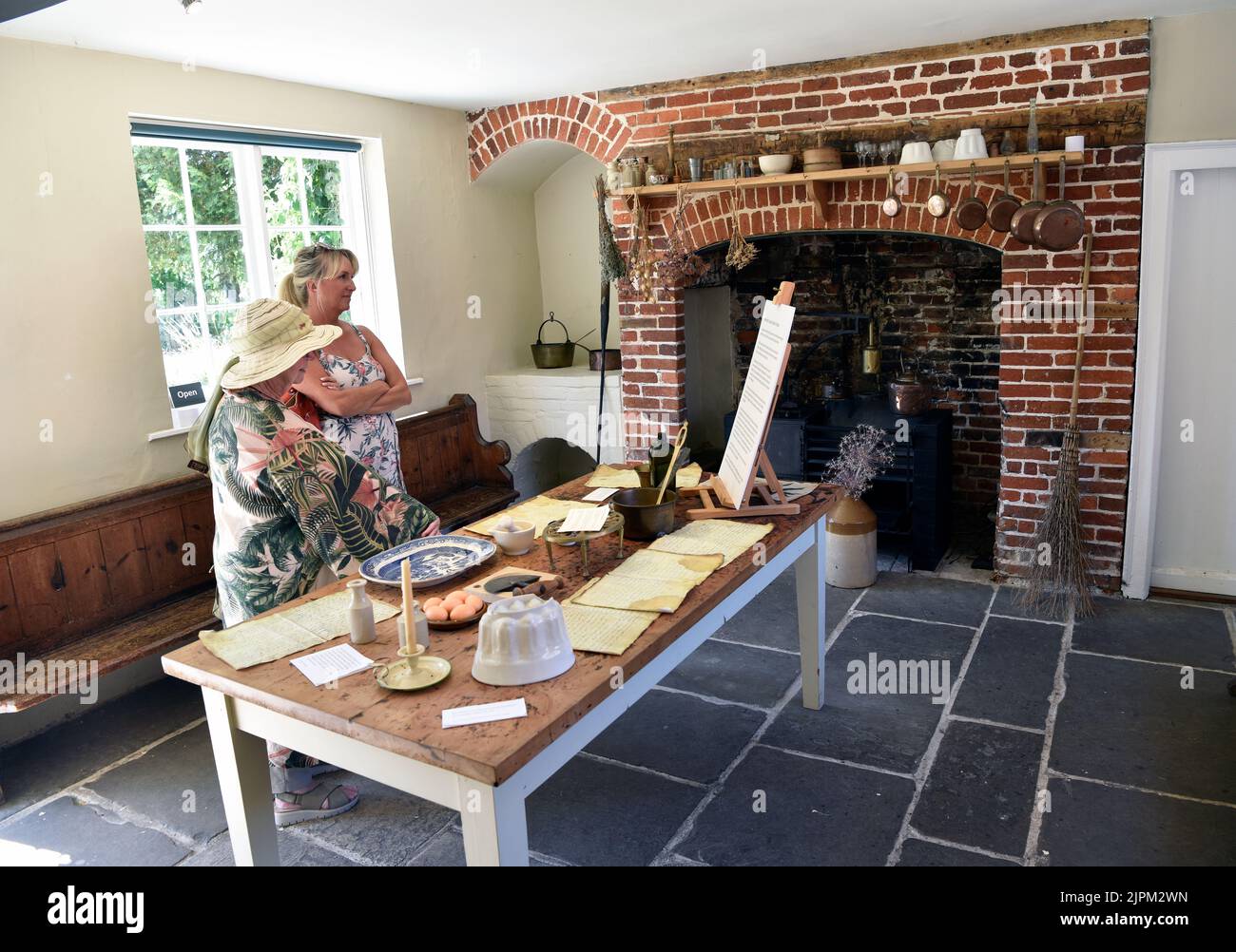 Visitors to Jane Austen’s House perusing items on display in the kitchen, Chawton, near Alton, Hampshire, UK. Stock Photo