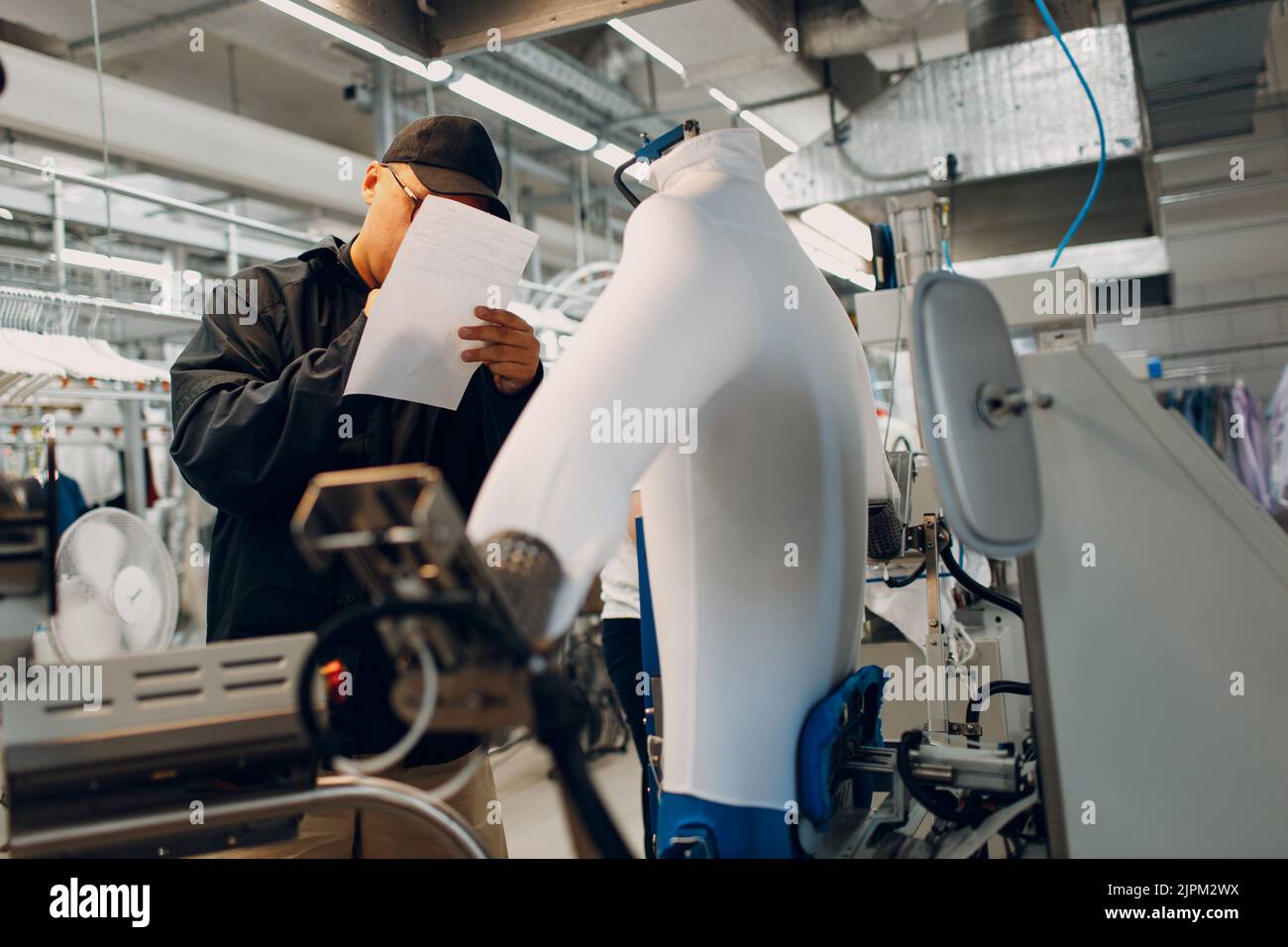 Worker working on Iron Dryer Mannequin steamer at Dry cleaning clothes