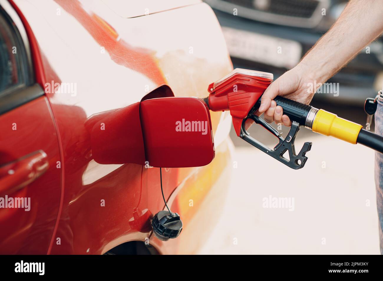 Man filling fuel tank in his hand at gas station Stock Photo - Alamy