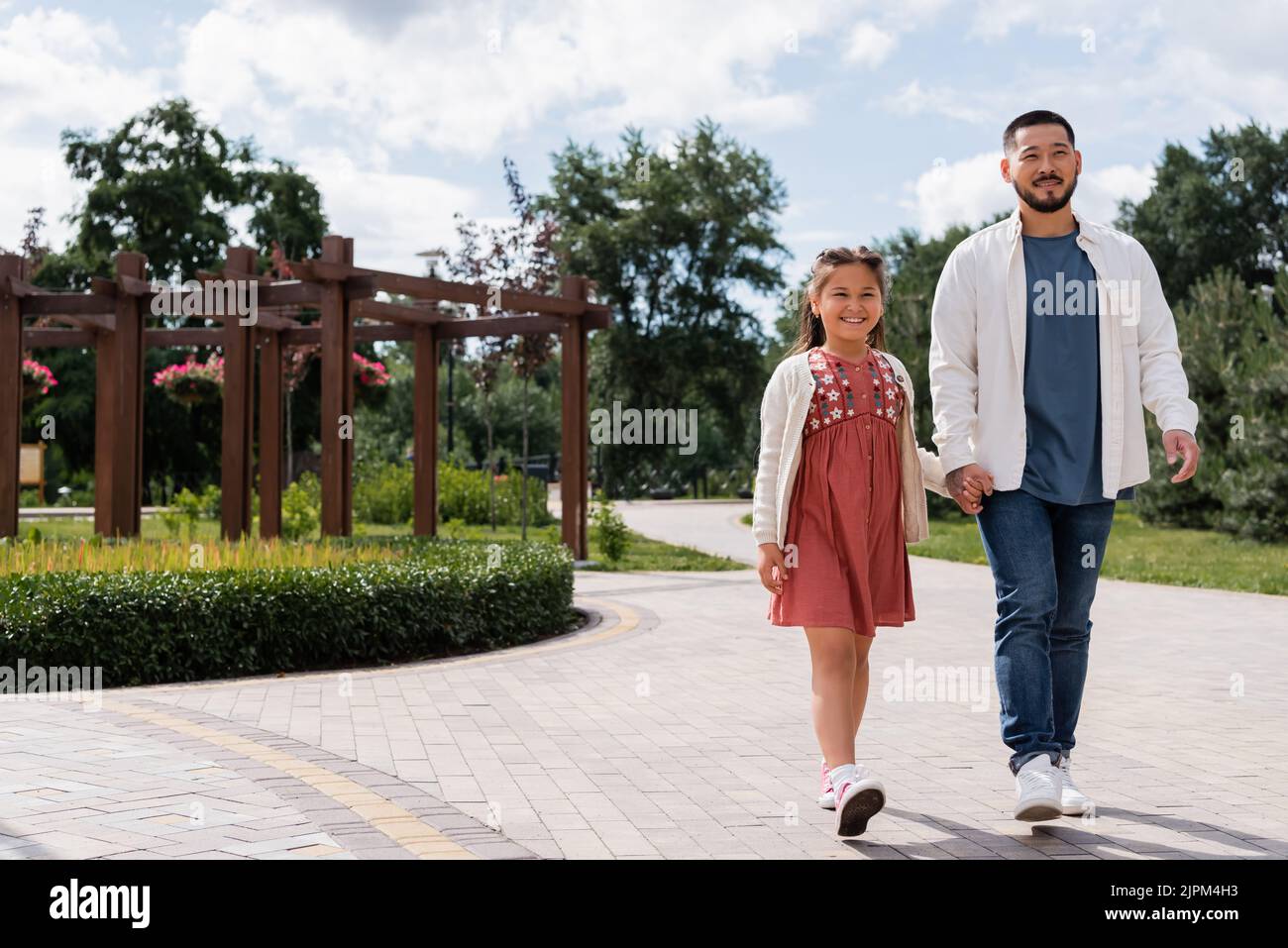 Asian dad and daughter walking in summer park Stock Photo - Alamy