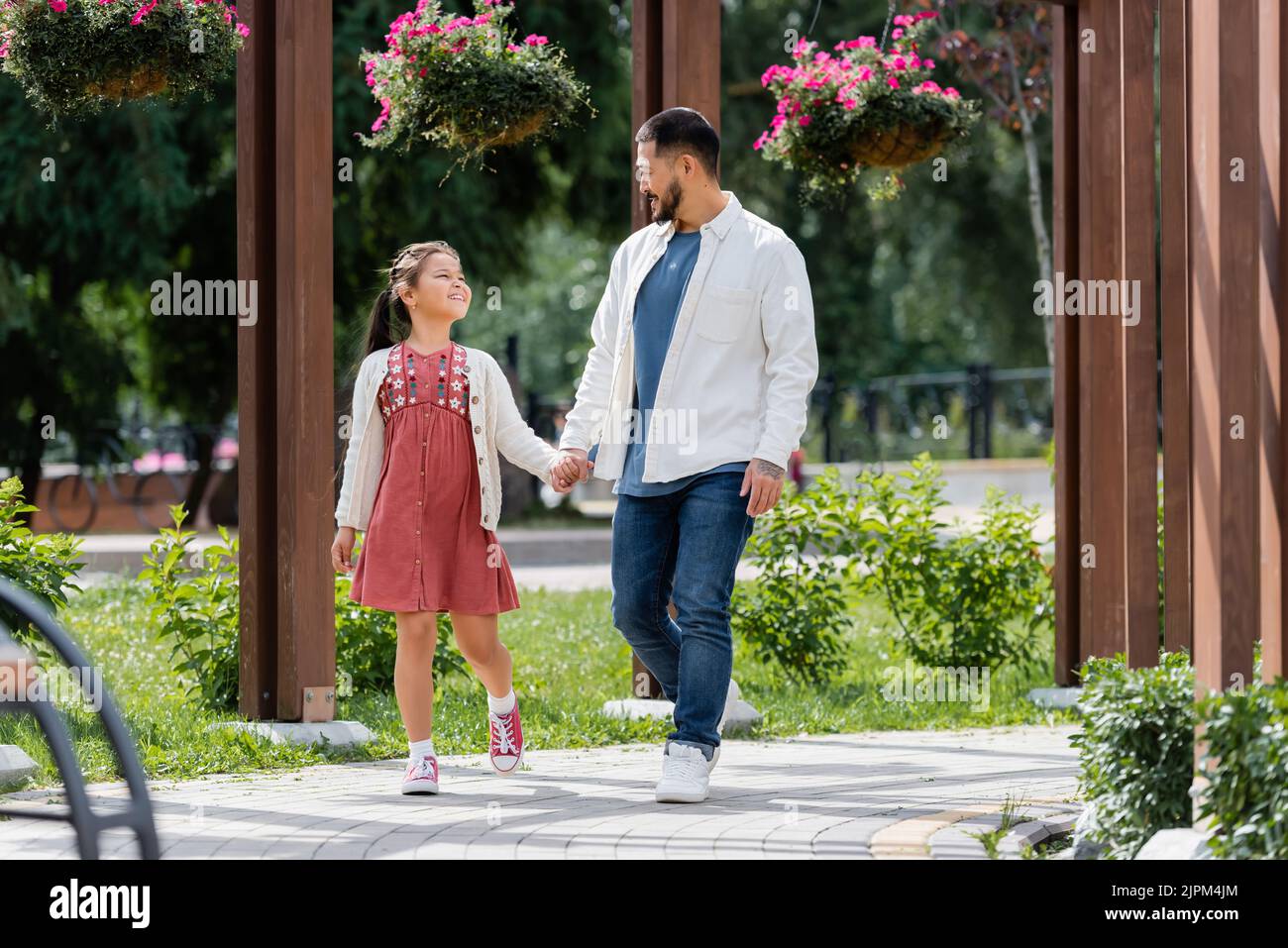 Happy asian family holding hands while walking in park Stock Photo - Alamy