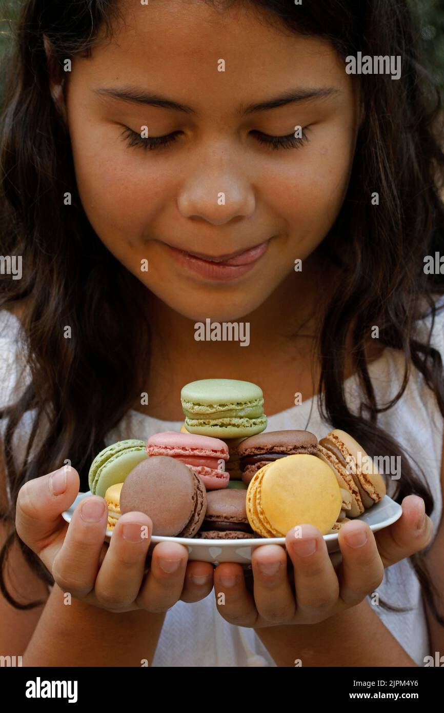 Delicious macaroons with a little girl. Stock Photo