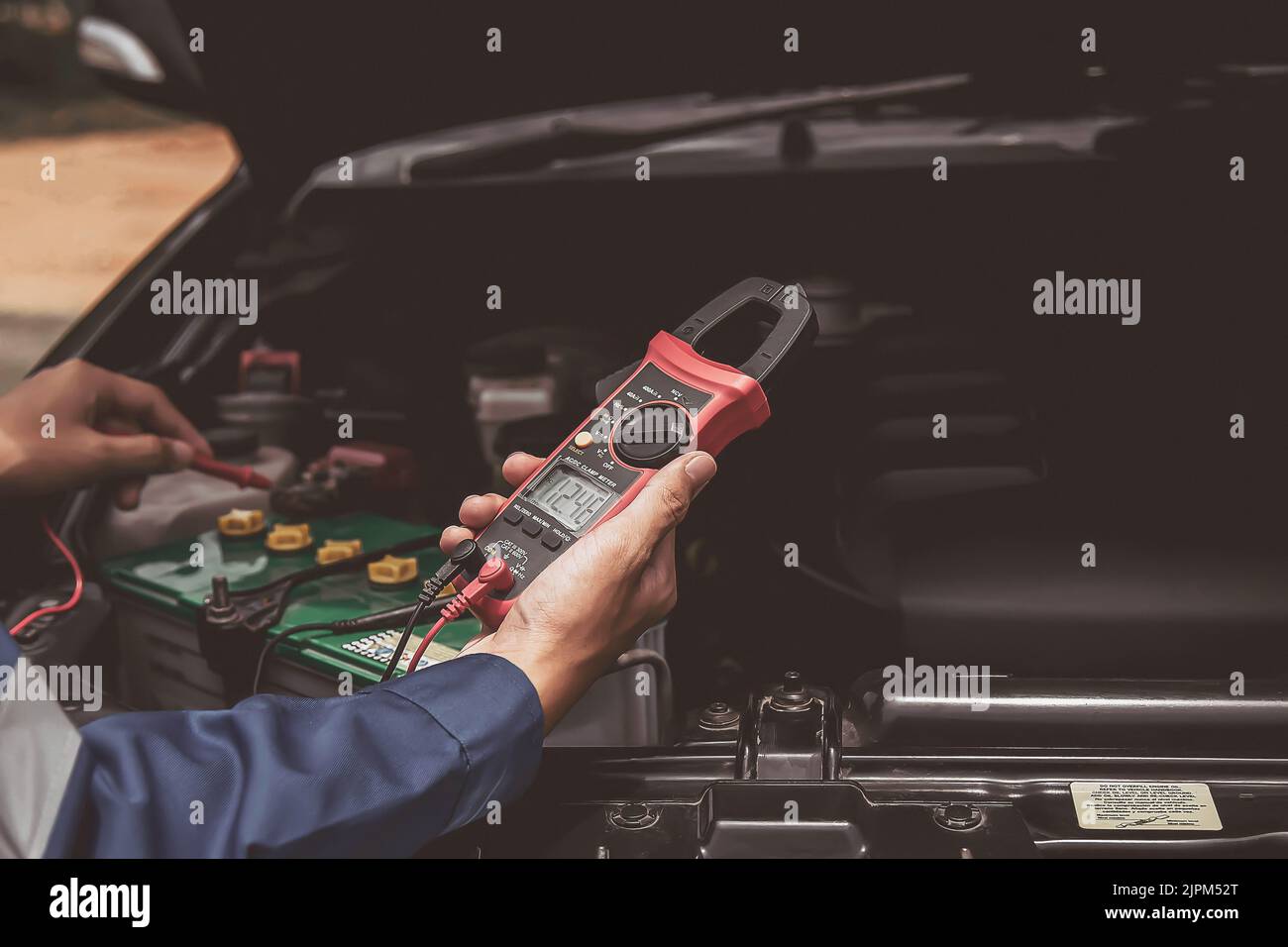 Mechanic checking the car's electrics with a multimeter Stock Photo - Alamy