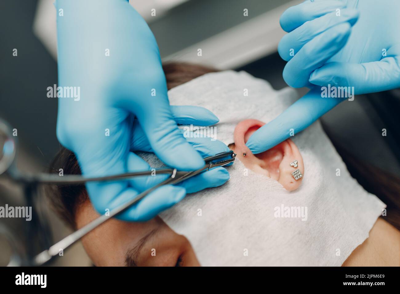 Young woman doing ear piercing at beauty studio salon Stock Photo Alamy