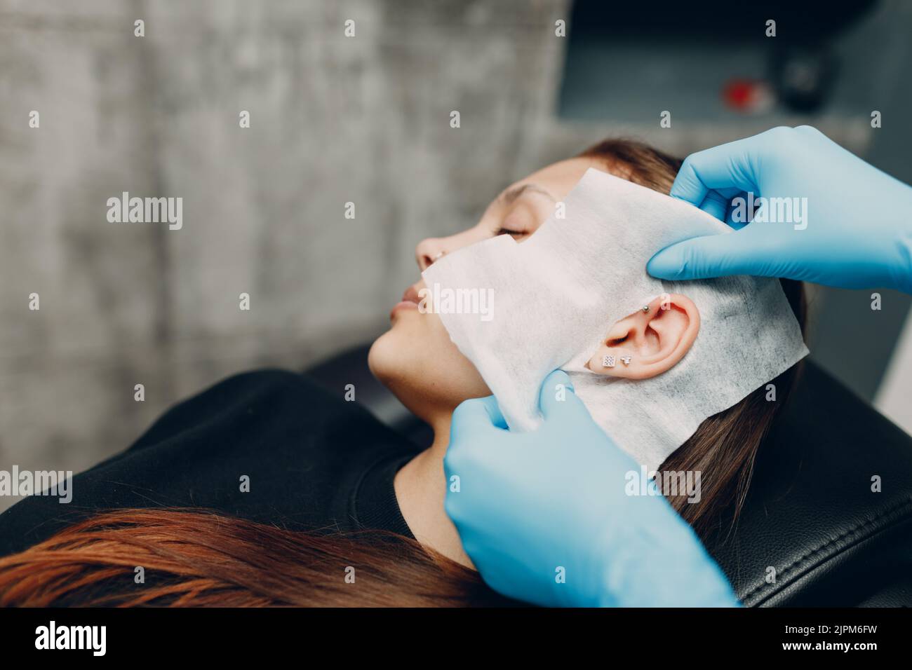 Young woman doing ear piercing at beauty studio salon Stock Photo Alamy