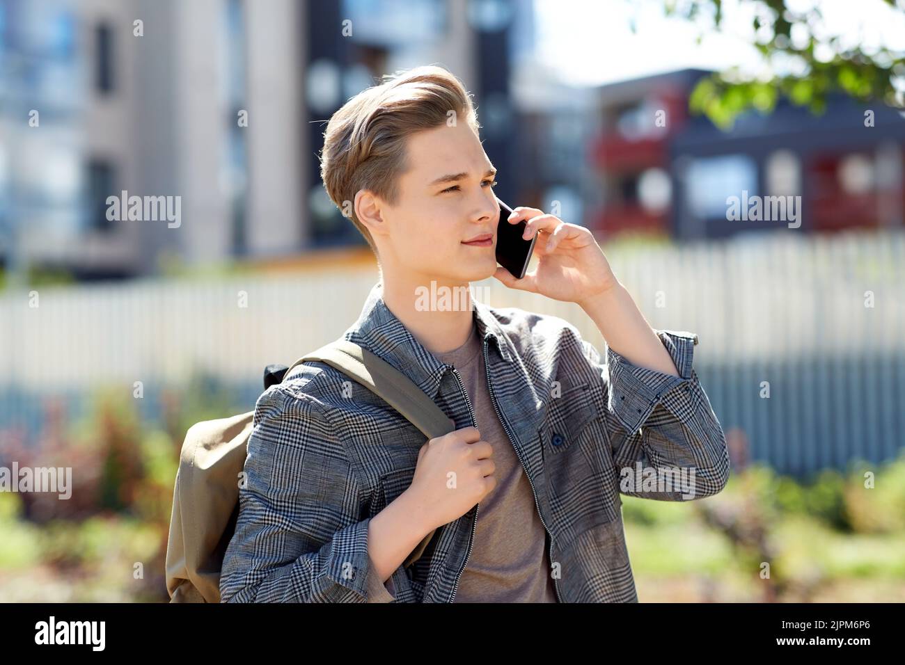 teenage student boy calling on smartphone in city Stock Photo