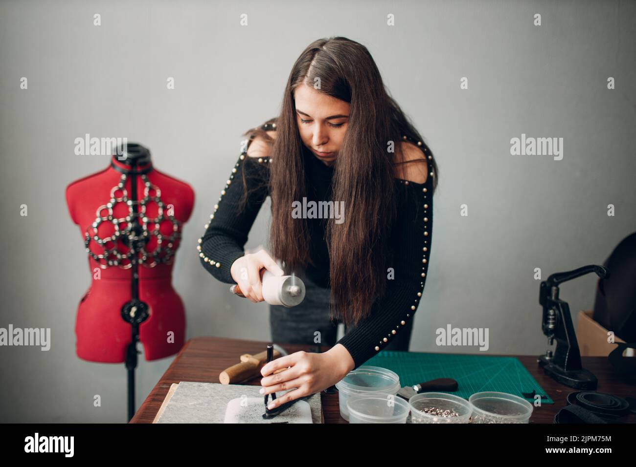 Tanner woman making leather harness belt goods on Working