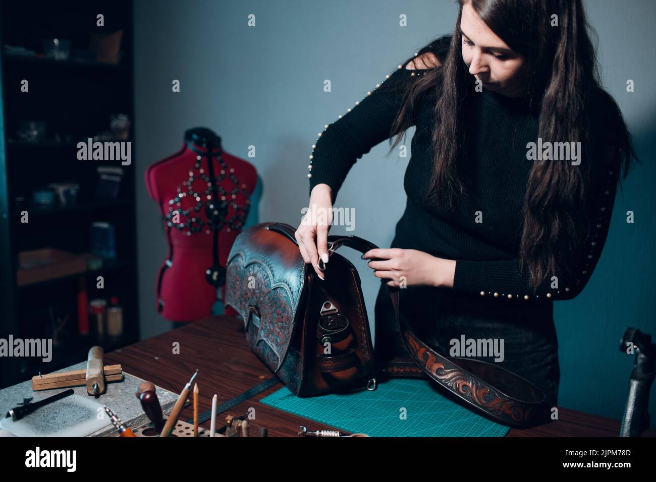 Tanner woman making sewing bag with pattern leather goods on