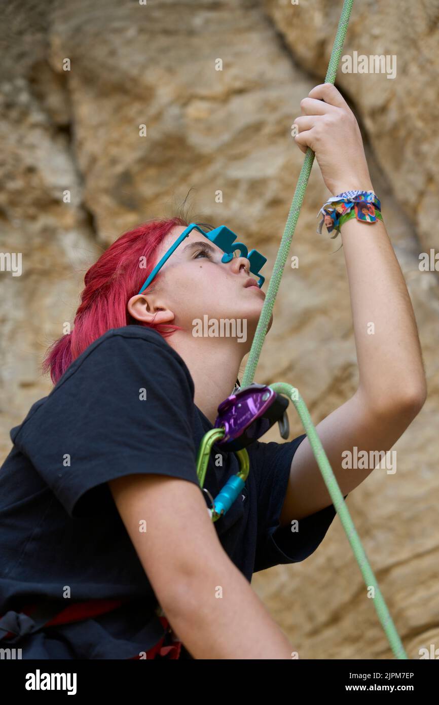 Teenage girl securing her climbing partner by a securing rope system ...