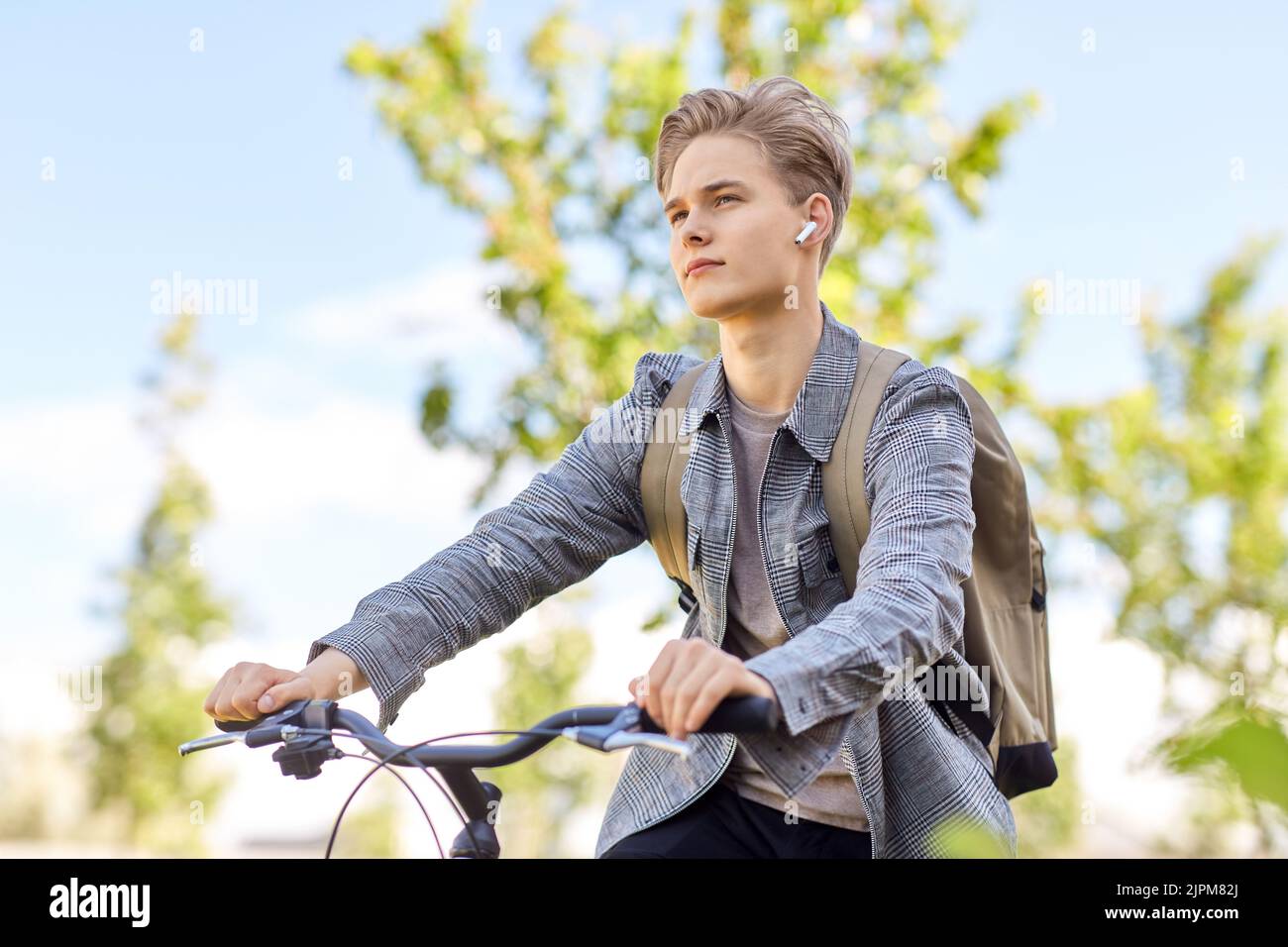 student boy with bag and earphones riding bicycle Stock Photo