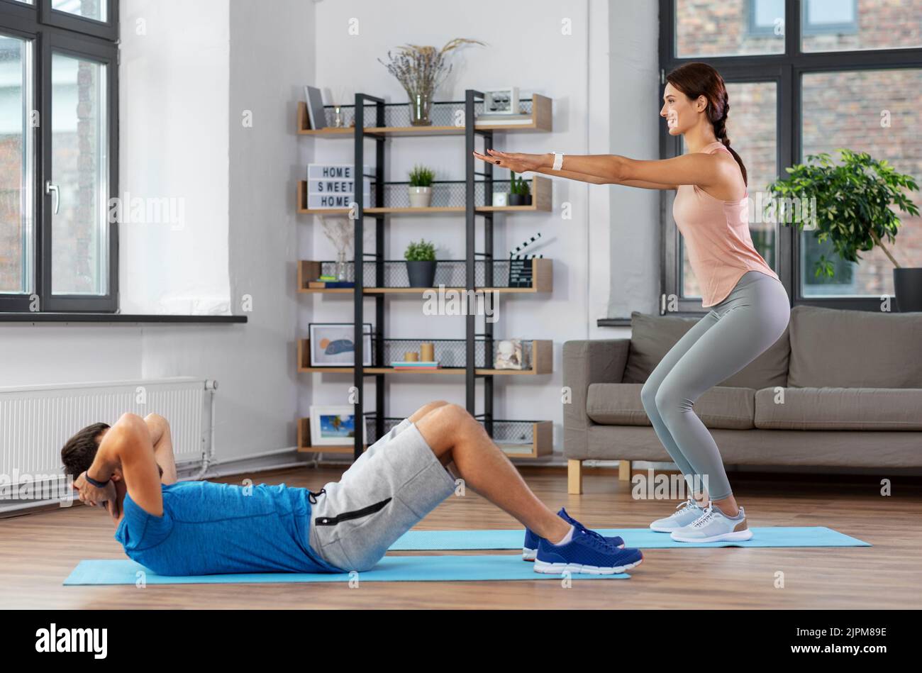 happy young man and woman exercising at home Stock Photo