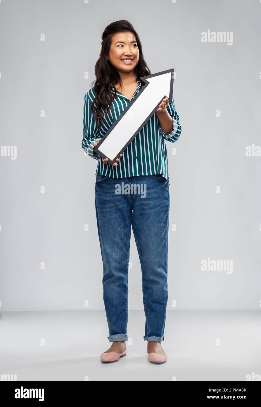 happy smiling asian woman with arrow pointing up Stock Photo - Alamy