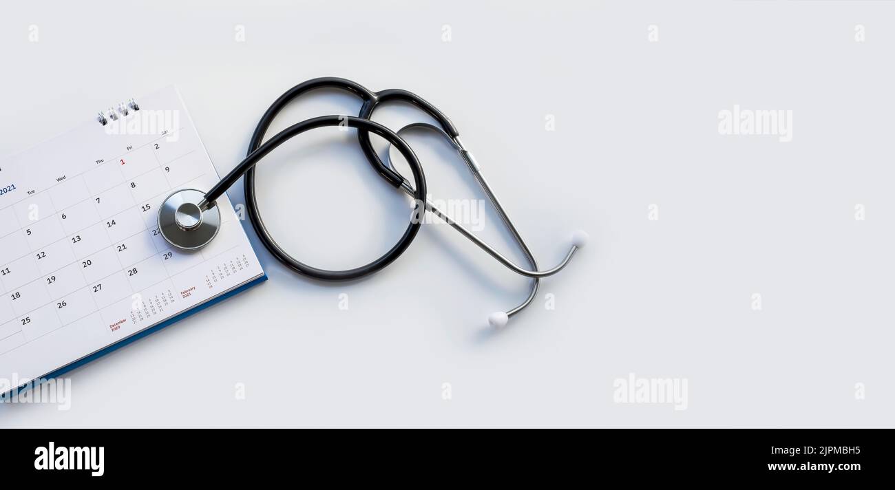 Headphones with date on the calendar page on a gray background Health care concept. Stock Photo