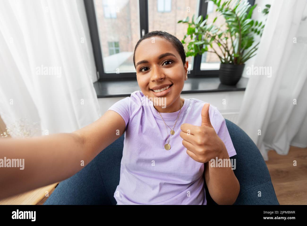 Thumbs up african woman sitting hi-res stock photography and images - Alamy