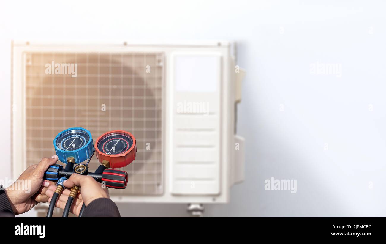 Air conditioner technician checking air conditioner operation Stock