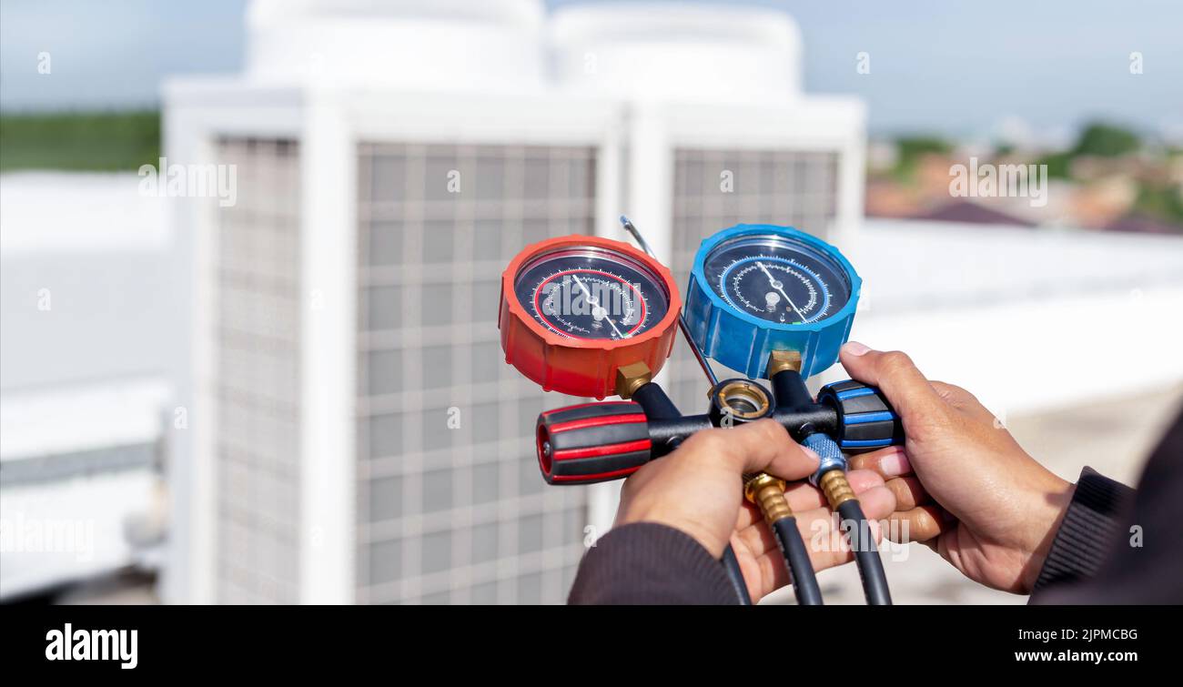 Air conditioner technician checking air conditioner operation Stock