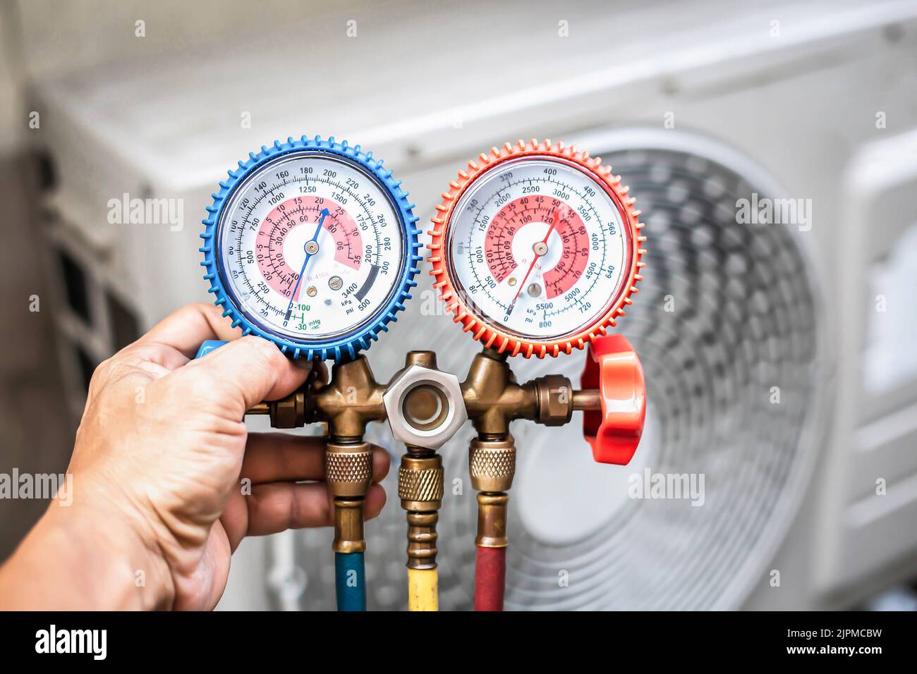 Air conditioner technician checking air conditioner operation Stock