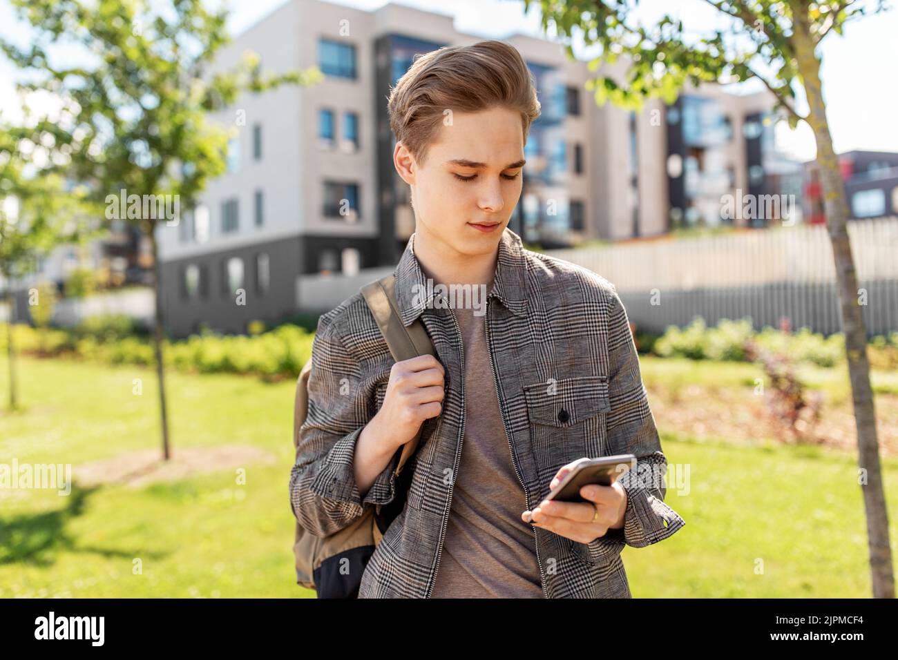 teenage student boy with phone and bag in city Stock Photo
