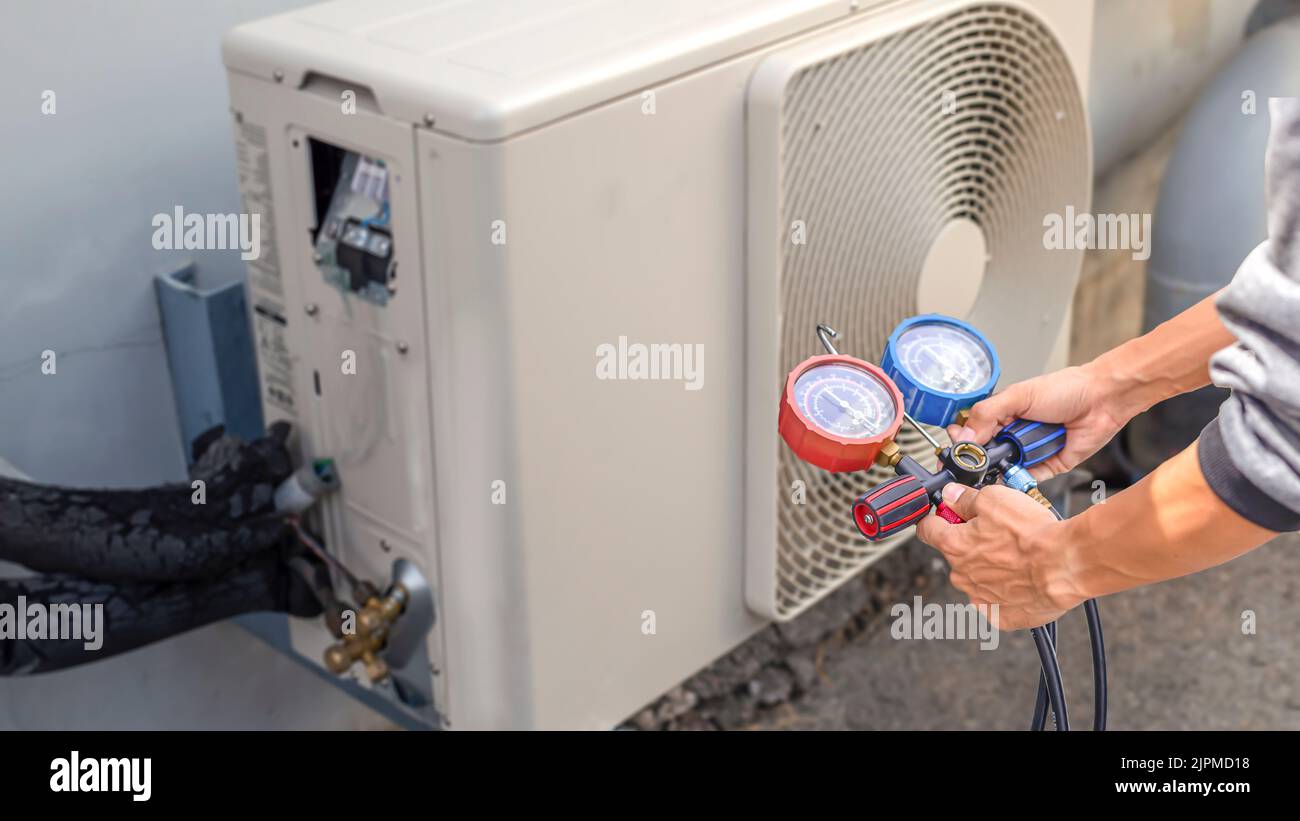 Air conditioner technician checking air conditioner operation Stock