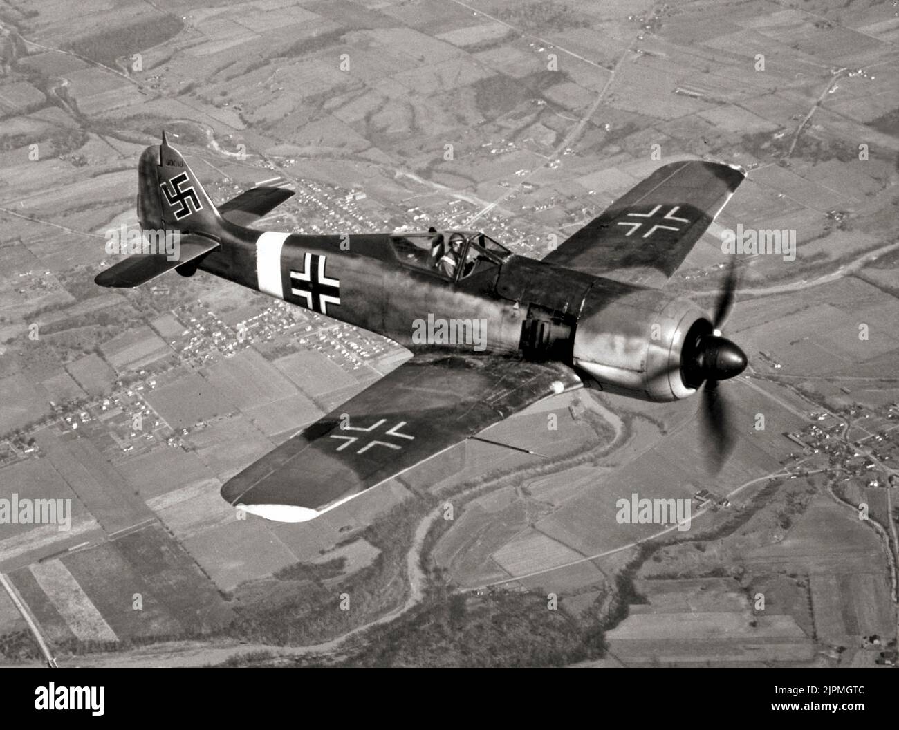 A German Focke-Wulf FW 190 fighter in flight. The aircraft was a German single-seat, single-engine fighter  designed in the late 1930s and started flying operationally over France in August 1941 and quickly proved superior in all but turn radius to the Spitfire Mk. V, the main front-line fighter of the Royal Air Force (RAF), particularly at low and medium altitudes.The 190 maintained superiority over Allied fighters until the introduction of the improved Spitfire Mk. IX. Stock Photo