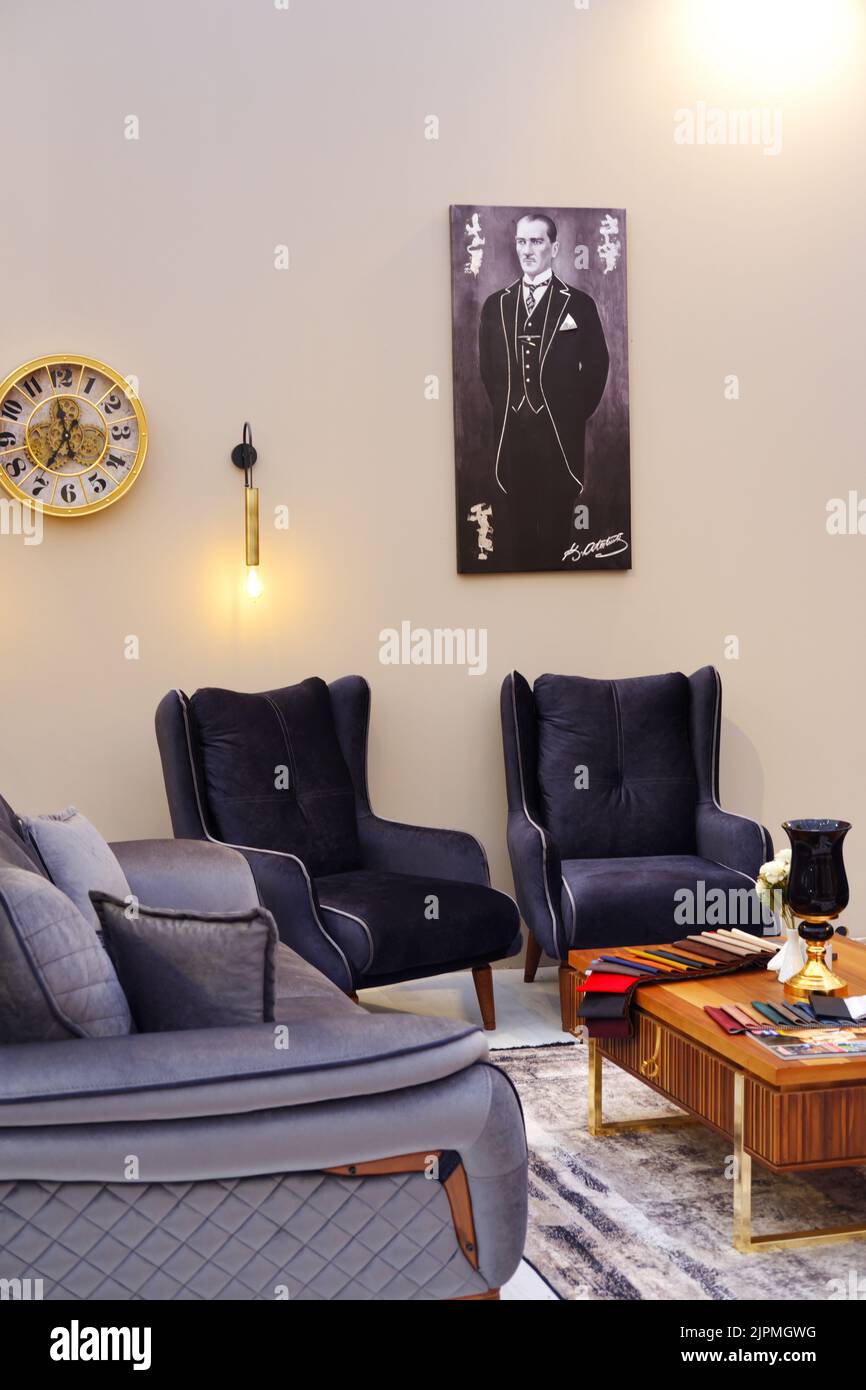 Navy blue armchairs at a modernly decorated room with vintage and spot lights. and Portrait of Mustafa Kemal Ataturk at the background Stock Photo