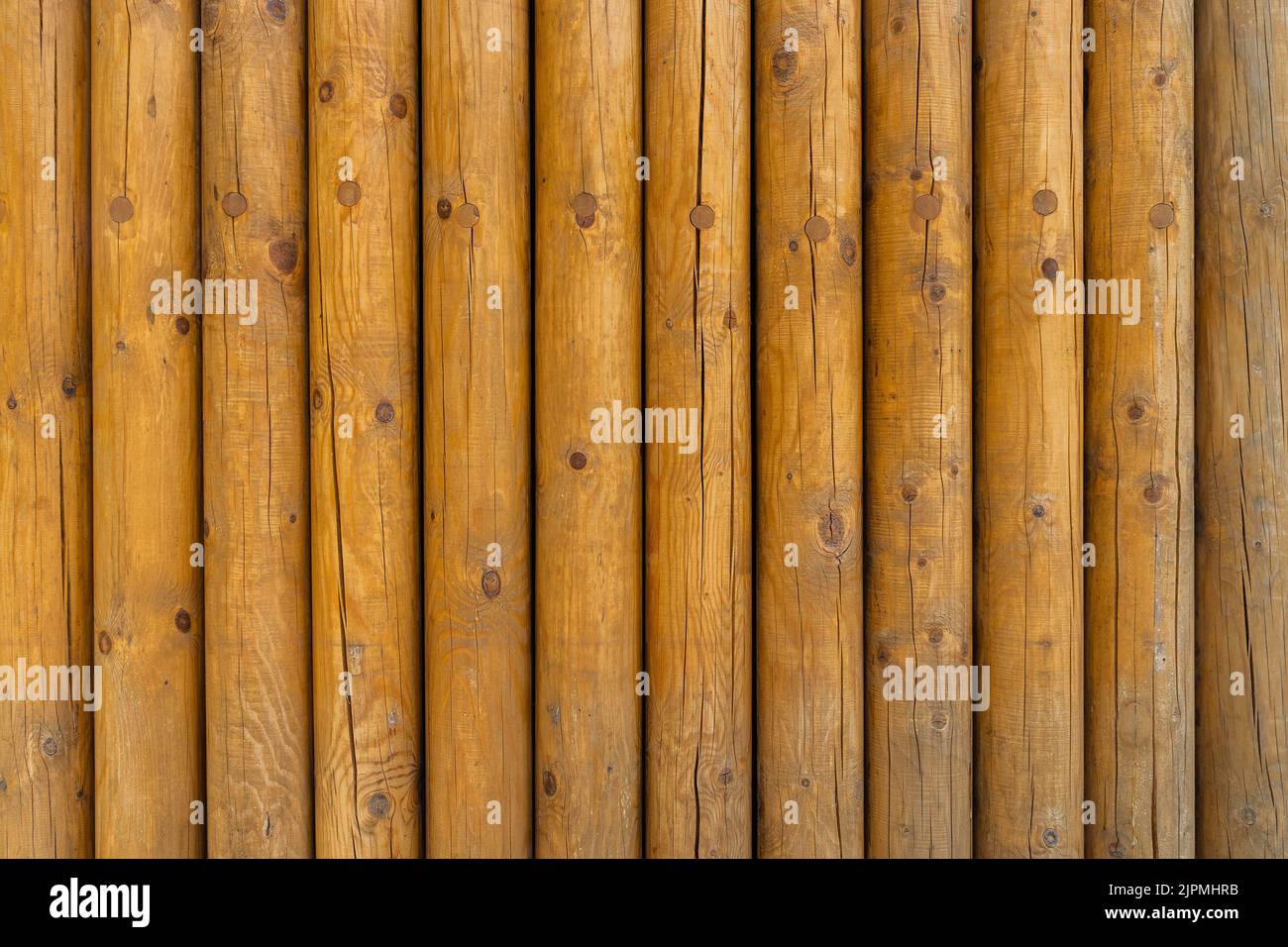 Texture or wall made of cylindrical wooden beams. Stock Photo