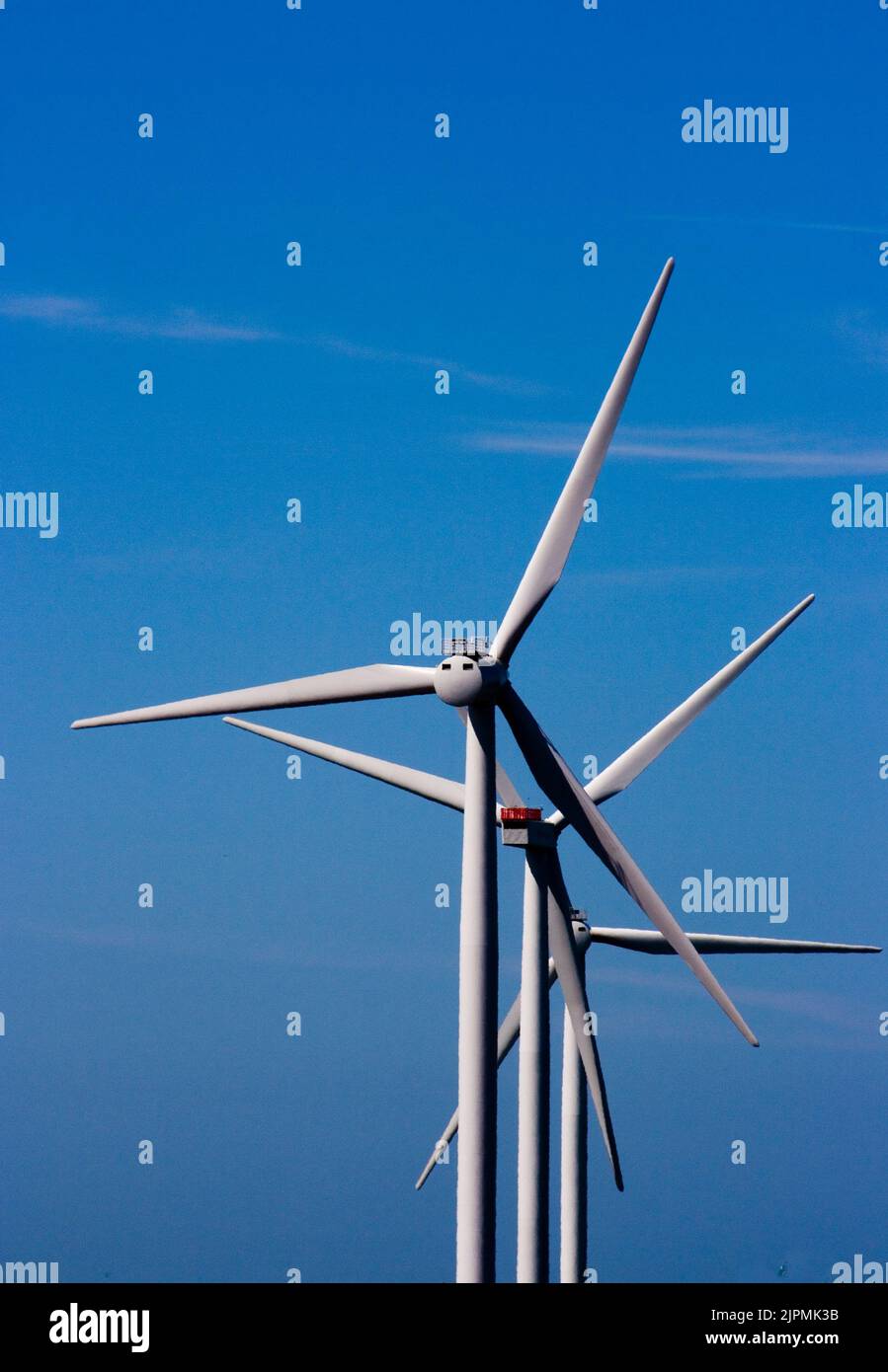 3 Windräder in Reihe hintereinander gegen blauen Himmel * three wind turbines in a row against blue sky Stock Photo
