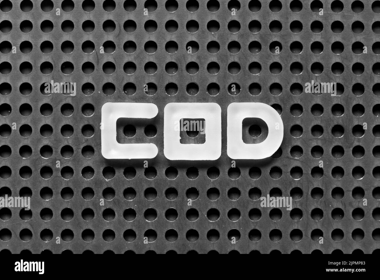White alphabet letter in word COD (Abbreviation of cash on delivery or cash on demand) on black