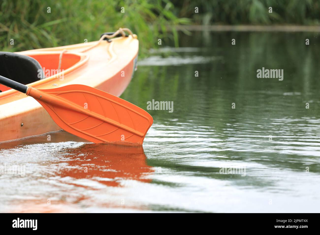 Kayak oar reflect in water surface close-up. River kayaking in summer day concept. Active vacations. Stock Photo