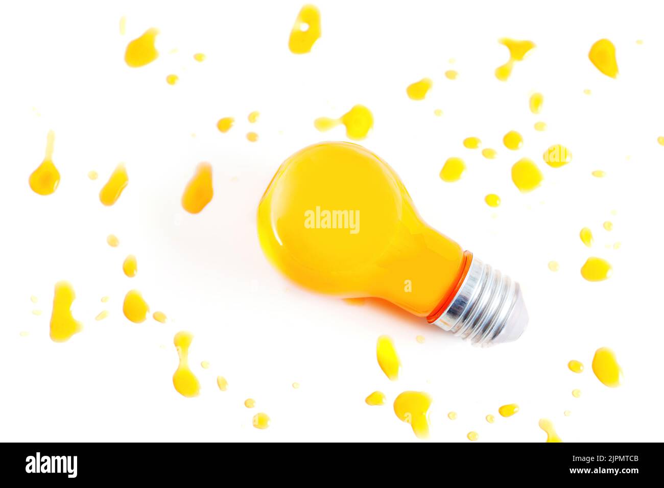Incandescent light bulb filled with orange juice on white background