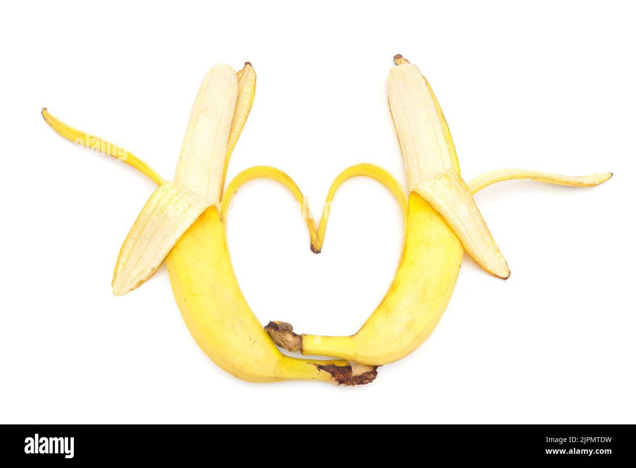 Two halfpeeled bananas make a heart shape isolated on white background