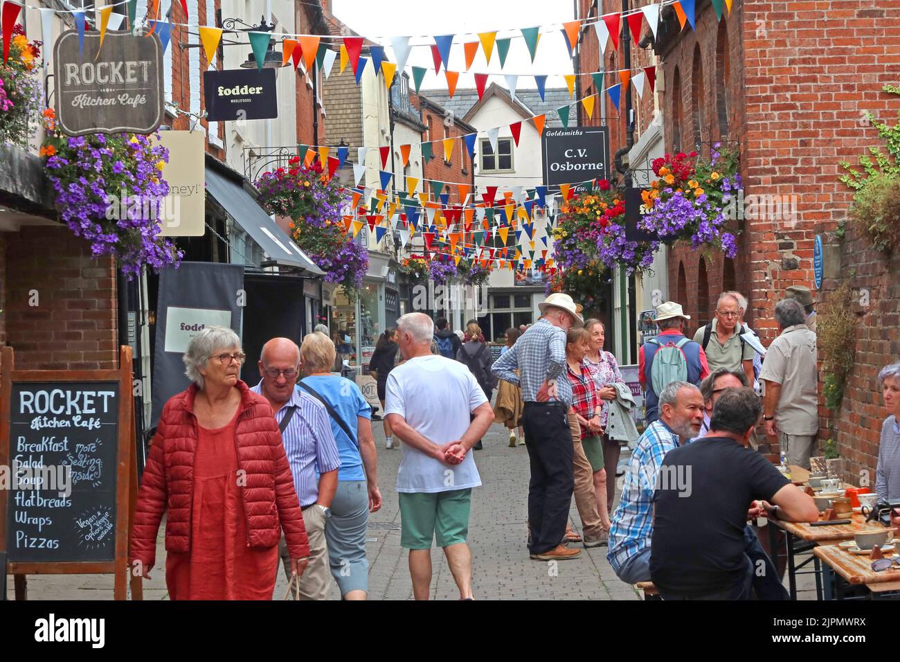 Church street visitors and tourists in Herefords narrow historic old town, eating al fresco at street tables, Herefordshire, England, UK, HR1 2LR Stock Photo