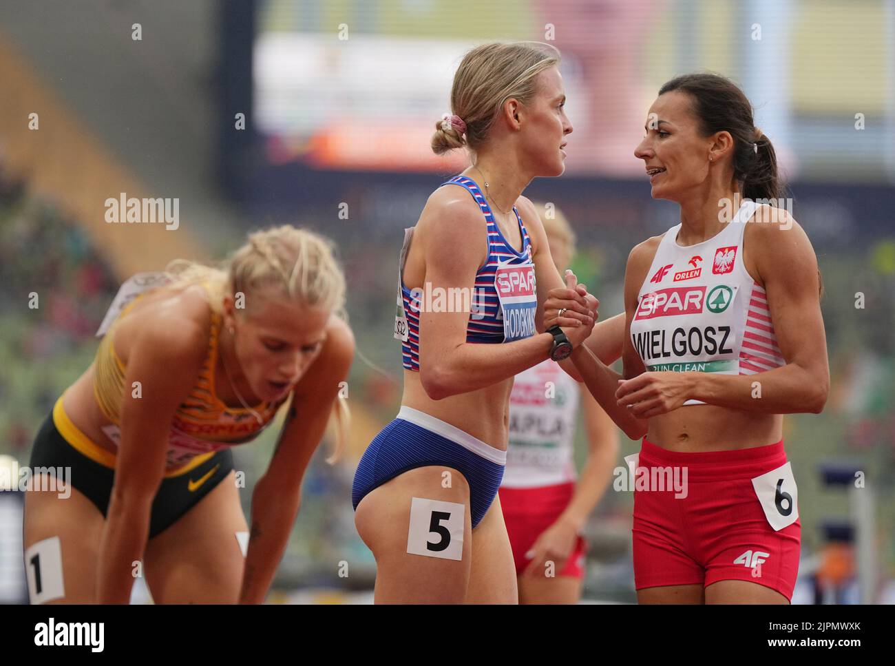 Munich, Germany. 19th Aug, 2022. Athletics: European Championships, Olympic Stadium, Semifinals, Women, 800 meters, Keely Hodgkinson (M, Great Britain) and Anna Wielgosz (r, Poland) shake hands after the race next to Majtie Kolberg (l, Germany). Credit: Soeren Stache/dpa/Alamy Live News Stock Photo